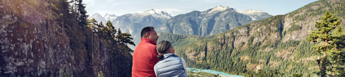 A mature African American couple enjoying the view of mountain ranges.