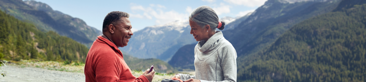 A mature African American couple against a mountain backdrop.